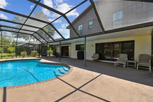 outdoor pool with a patio area and glass enclosure