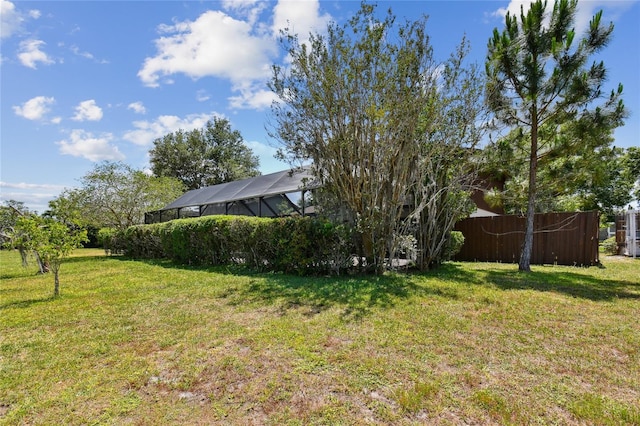 view of yard featuring a lanai and fence