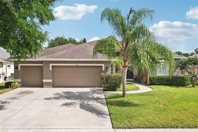 ranch-style home featuring stucco siding, an attached garage, driveway, a front lawn, and roof with shingles