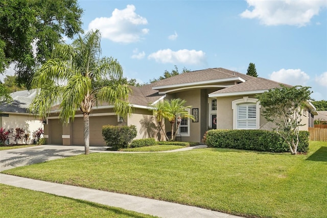 view of front facade with stucco siding, a garage, driveway, and a front yard