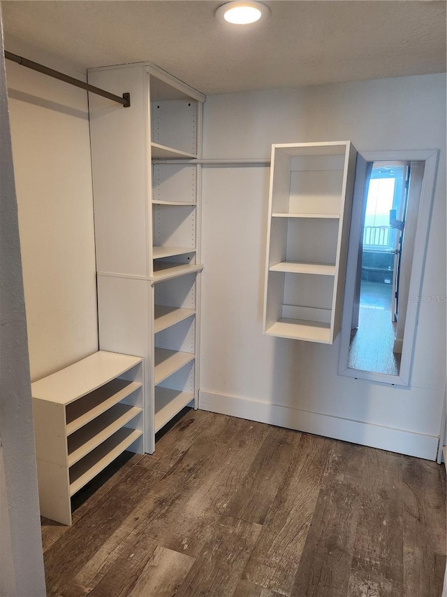walk in closet with wood finished floors