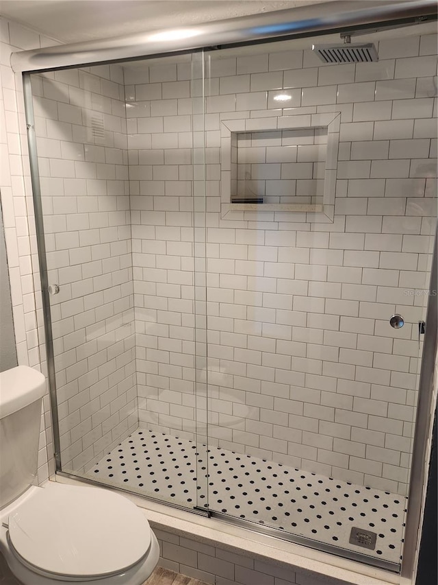 full bathroom with a stall shower and toilet