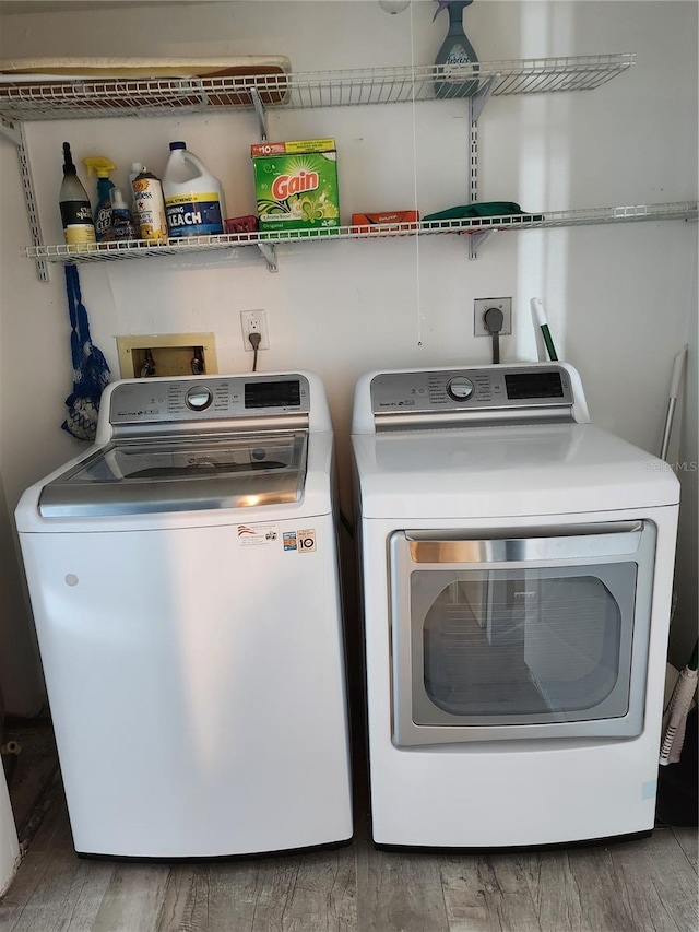 laundry area with independent washer and dryer and wood finished floors