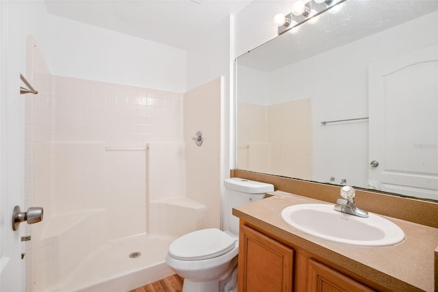 bathroom with toilet, walk in shower, vanity, and wood finished floors