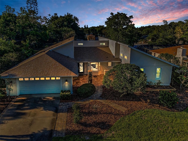 833 Lakeside Ter, Palm Harbor, FL 34683 - mid-century home featuring a chimney, driveway, a shingled roof, and a garage