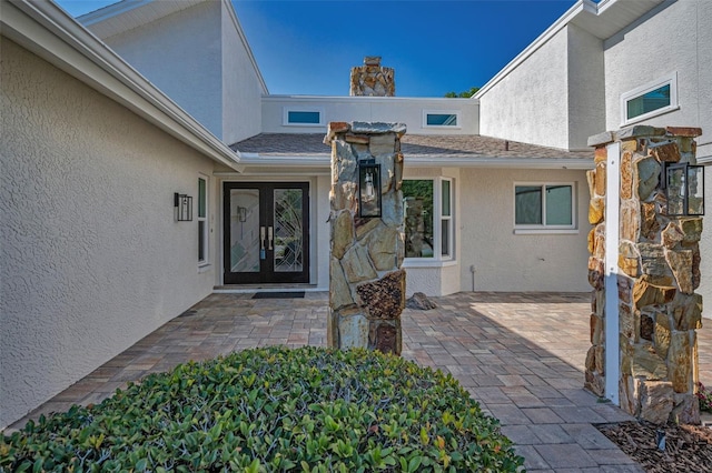 833 Lakeside Ter, Palm Harbor, FL 34683 - entrance to property with french doors, a patio, stucco siding, and a chimney