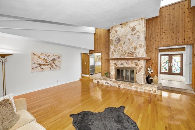 833 Lakeside Ter, Palm Harbor, FL 34683 - unfurnished living room with baseboards, wood walls, wood finished floors, and a fireplace