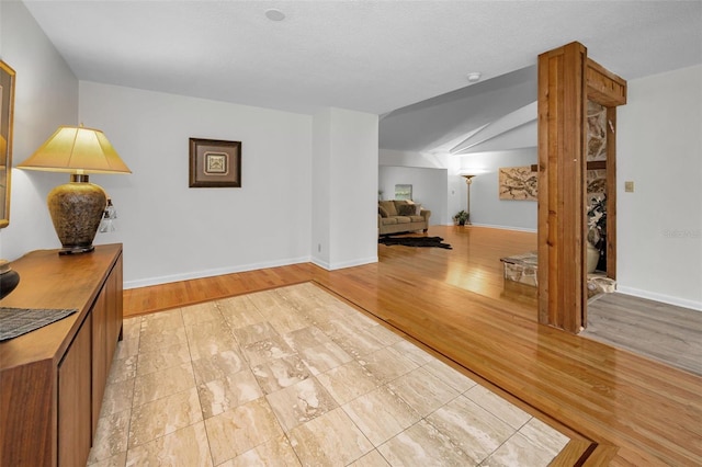 833 Lakeside Ter, Palm Harbor, FL 34683 - corridor featuring light wood-style floors, baseboards, and vaulted ceiling