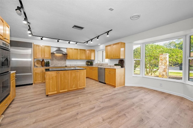 833 Lakeside Ter, Palm Harbor, FL 34683 - kitchen with visible vents, wall chimney exhaust hood, a sink, light wood-style flooring, and appliances with stainless steel finishes