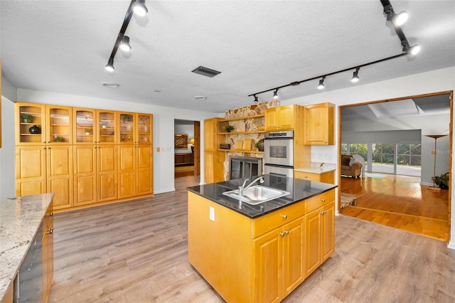 833 Lakeside Ter, Palm Harbor, FL 34683 - kitchen featuring a sink, track lighting, double oven, and light wood finished floors