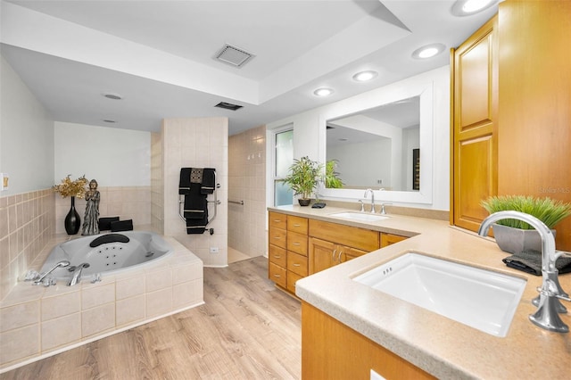833 Lakeside Ter, Palm Harbor, FL 34683 - full bathroom featuring a jetted tub, vanity, wood finished floors, and visible vents