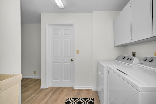 833 Lakeside Ter, Palm Harbor, FL 34683 - laundry room featuring cabinet space, baseboards, washer and clothes dryer, and light wood-style flooring