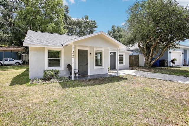 bungalow-style house featuring a porch, fence, stucco siding, a front yard, and a shingled roof