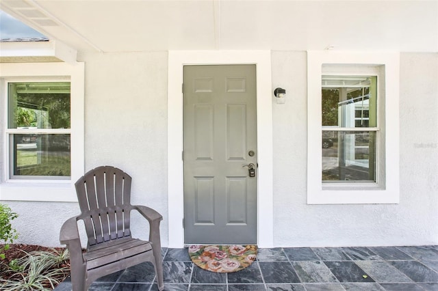 doorway to property featuring stucco siding