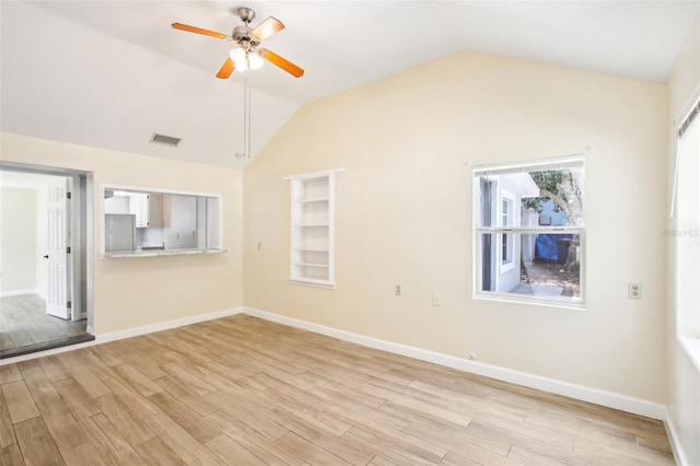 unfurnished living room featuring light wood finished floors, a ceiling fan, visible vents, and lofted ceiling