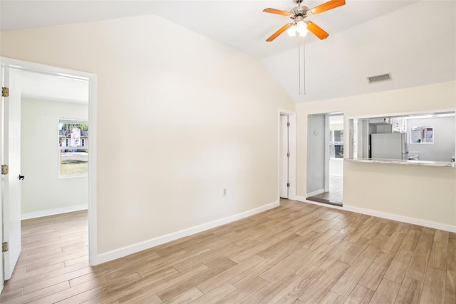 unfurnished living room featuring light wood-type flooring, visible vents, a ceiling fan, and vaulted ceiling