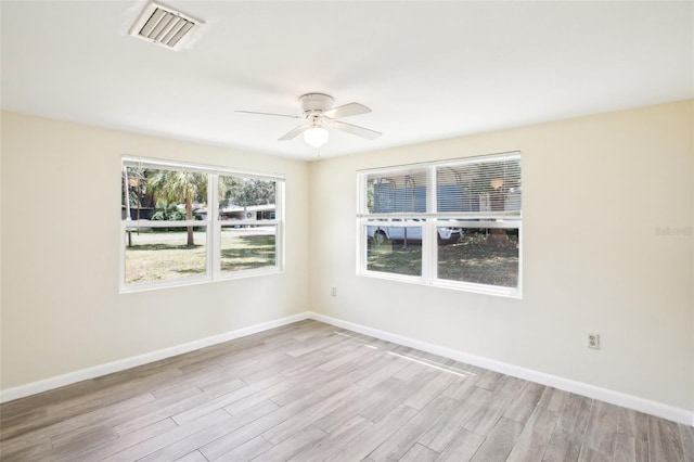 unfurnished room with light wood-type flooring, ceiling fan, baseboards, and visible vents