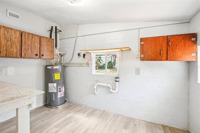 utilities with water heater and visible vents