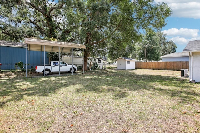 view of yard featuring an outbuilding, fence, cooling unit, a shed, and a carport