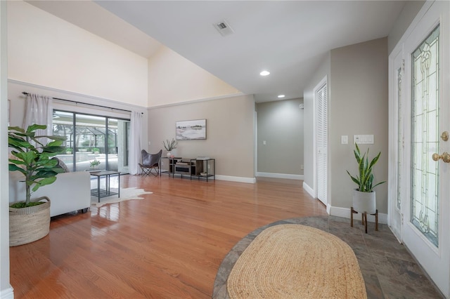 foyer entrance with baseboards, recessed lighting, wood finished floors, and visible vents