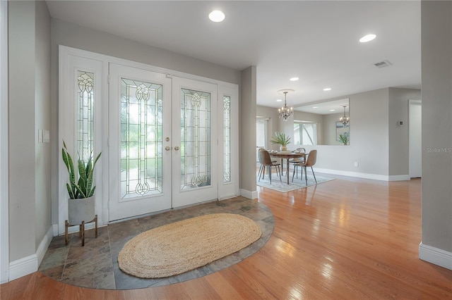 entryway featuring french doors, baseboards, a chandelier, and visible vents