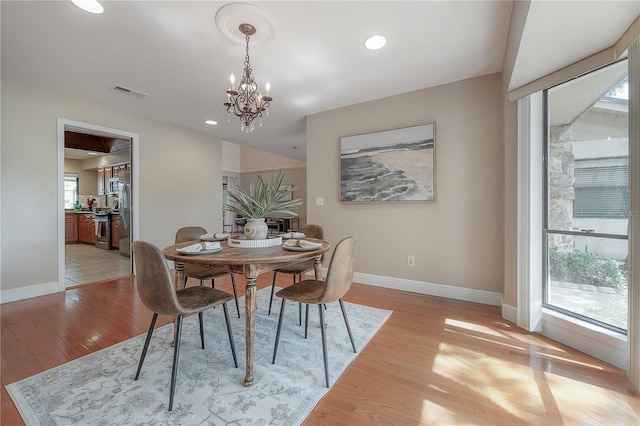 dining area featuring visible vents, light wood-style floors, baseboards, recessed lighting, and a notable chandelier