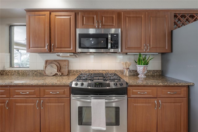 kitchen with appliances with stainless steel finishes, decorative backsplash, and brown cabinetry