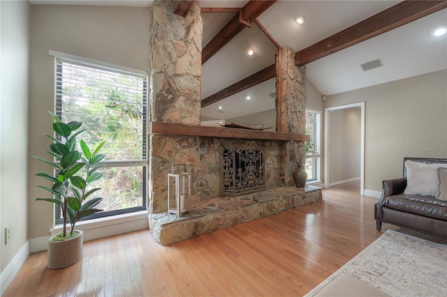 living area featuring visible vents, wood-type flooring, baseboards, and beamed ceiling