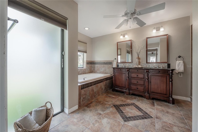 bathroom with vanity, a ceiling fan, baseboards, and a bath