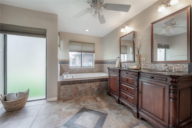 full bath with double vanity, a sink, ceiling fan, and a bath