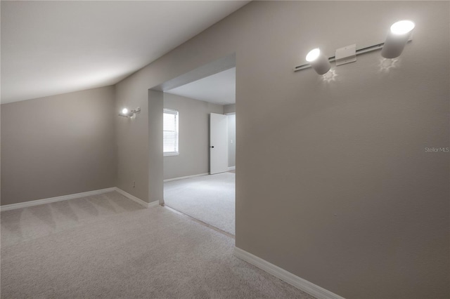 hallway featuring baseboards and light carpet