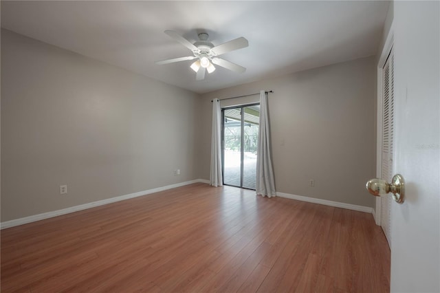 spare room featuring baseboards, ceiling fan, and light wood-type flooring