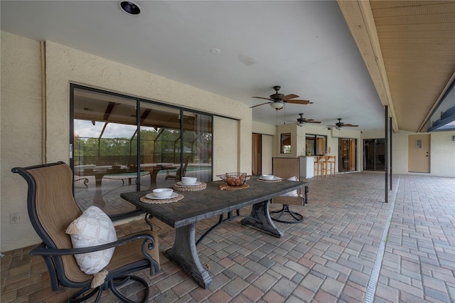 view of patio with outdoor dining area and a ceiling fan