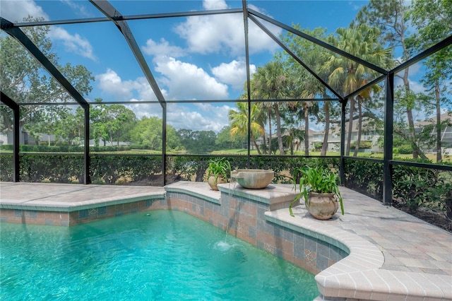 pool featuring glass enclosure and a patio