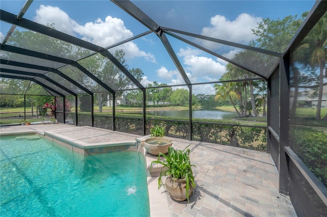 view of pool featuring a patio, a water view, glass enclosure, and a pool with connected hot tub