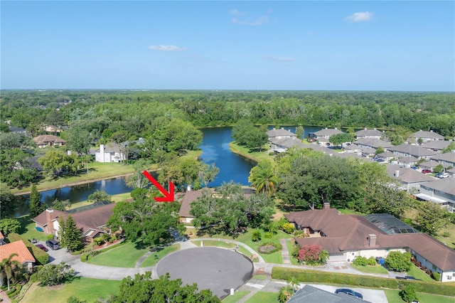 drone / aerial view with a water view, a view of trees, and a residential view