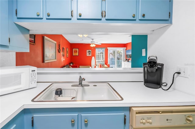 250 Medallion Blvd Unit H, Madeira Beach, FL 33708 - kitchen with a sink, light countertops, white microwave, dishwashing machine, and blue cabinets