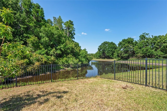 view of yard with a water view and fence