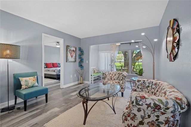 living area with baseboards and wood finished floors