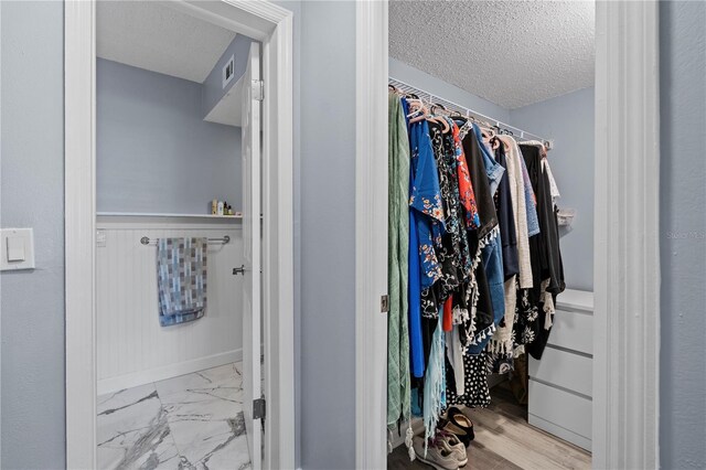 walk in closet featuring visible vents and marble finish floor