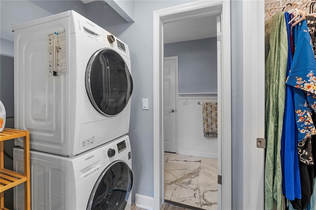 washroom with baseboards, laundry area, marble finish floor, and stacked washer / drying machine