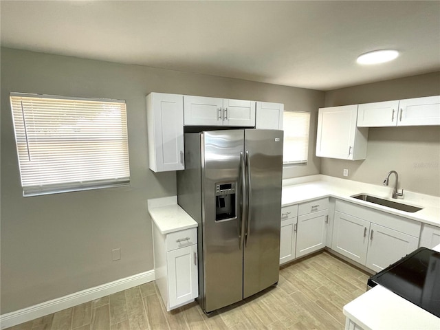 8310 Croton Ave, Tampa, FL 33619 - kitchen with light countertops, a sink, white cabinets, and stainless steel fridge with ice dispenser