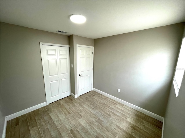 8310 Croton Ave, Tampa, FL 33619 - unfurnished bedroom with visible vents, baseboards, wood finished floors, and a closet
