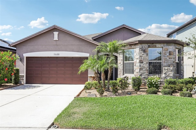 11688 Brighton Knoll Loop, Riverview, FL 33579 - view of front of home with stone siding, a garage, a front lawn, and stucco siding