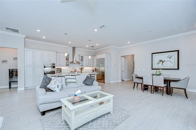 living room with recessed lighting, baseboards, visible vents, and ornamental molding