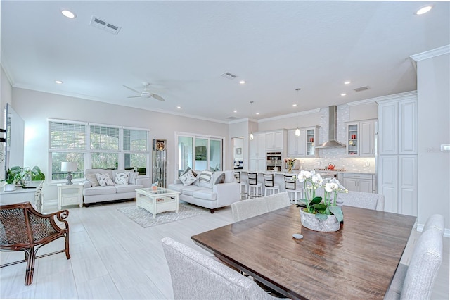 dining space featuring a ceiling fan, visible vents, and ornamental molding