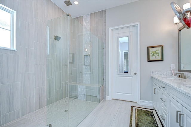 bathroom featuring vanity, tiled shower, and visible vents