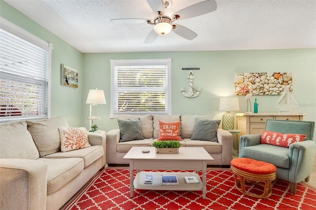 living room with a ceiling fan and a textured ceiling