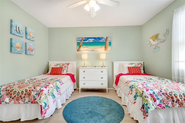 bedroom featuring ceiling fan, multiple windows, and wood finished floors