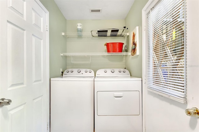 laundry area featuring laundry area, washing machine and dryer, and visible vents